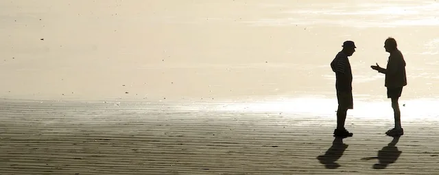 Zwei Menschen im Gespräch am Strand